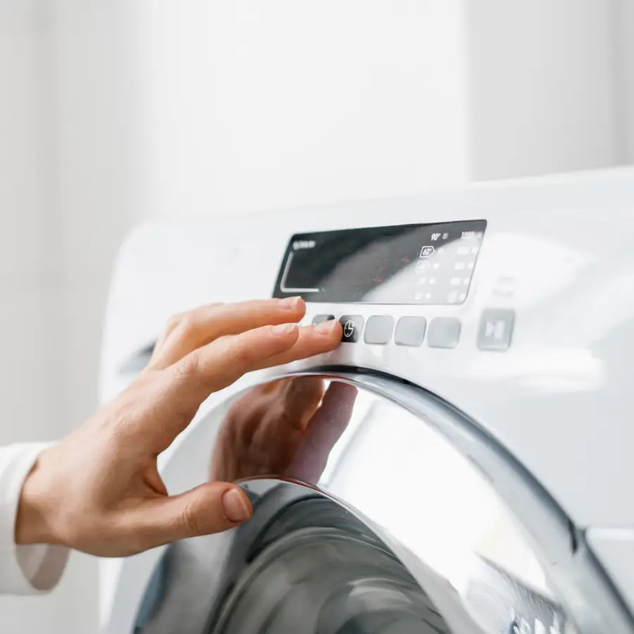 Mujer poniendo en marcha una lavadora